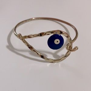 Gold tone bangle bracelet with eye